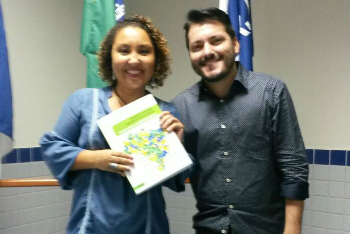 A professora apresenta o livro sobre a experiência da língua estrangeira nos Institutos