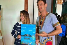 Julia com sua tela 'Lagoa Limpa', na exposição