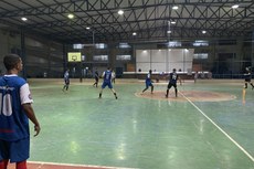 Equipes em quadra na disputa de futsal. 